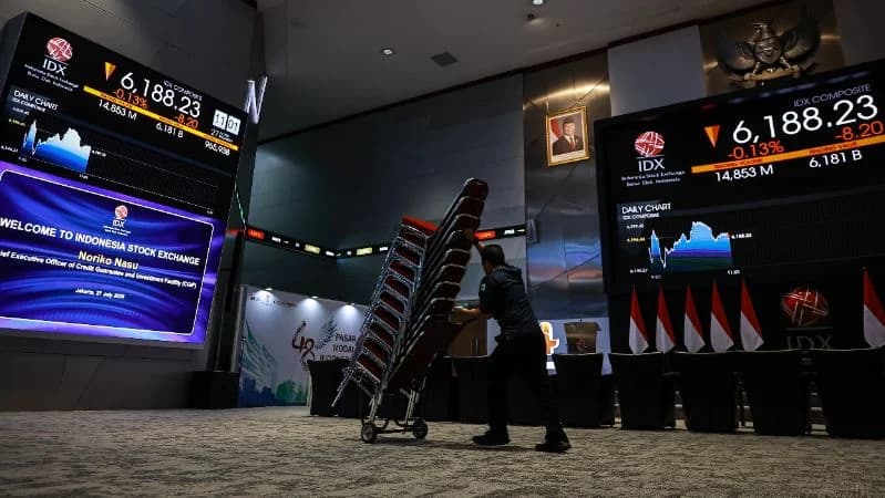 Pekerja melintas di dekat layar pergerakan Indeks Harga Saham Gabungan (IHSG) di Bursa Efek Indonesia (BEI), Jakarta.