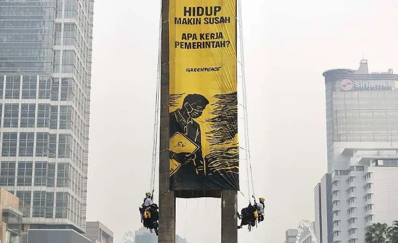 Aktivis Greenpeace saat panjat Patung Selamat Datang untuk bentangkan spanduk protes di Bundaran HI.