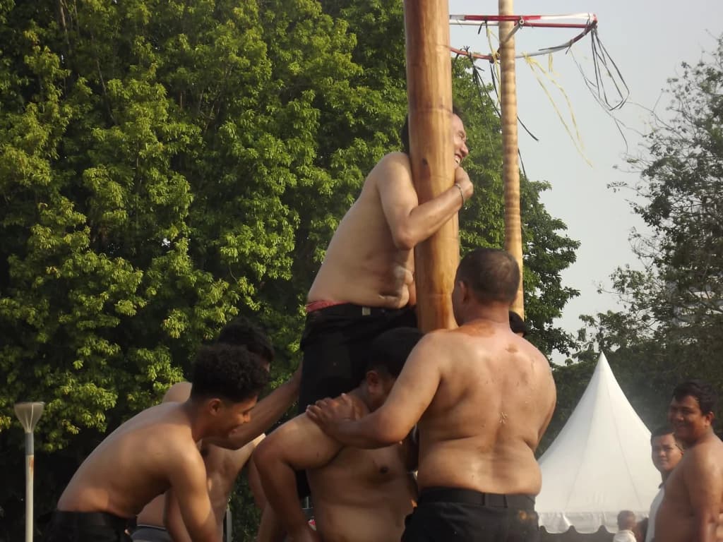 Serunya Panjat Pinang di Monas, Peserta Jatuh Bangun Berebut Hadiah