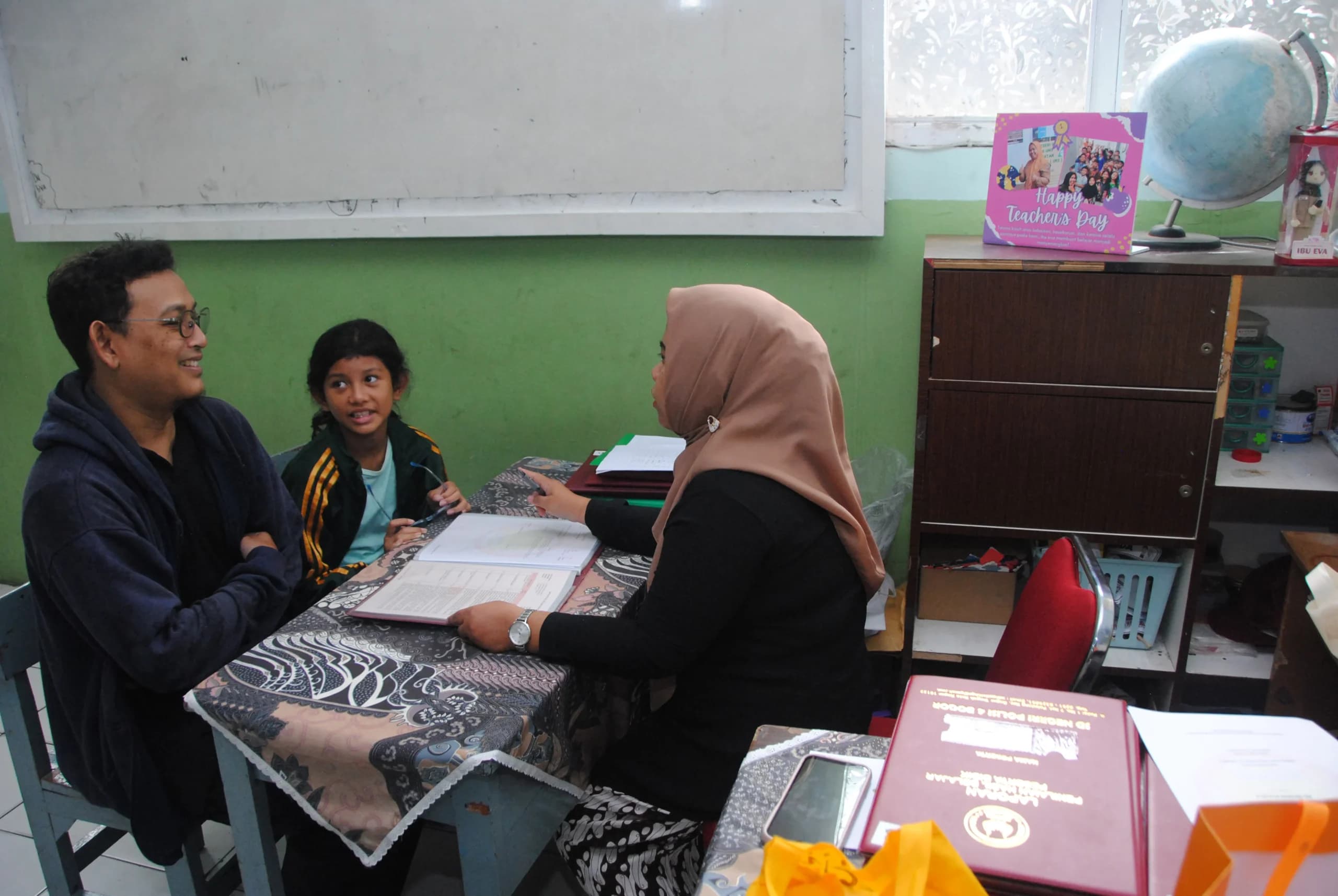 Guru berbincang dengan orang tua murid saat pembagian rapor di SDN Polisi 4, Kota Bogor, Jawa Barat Guru berbincang dengan orang tua murid saat pembagian rapor di SDN Polisi 4, Kota Bogor, Jawa Barat