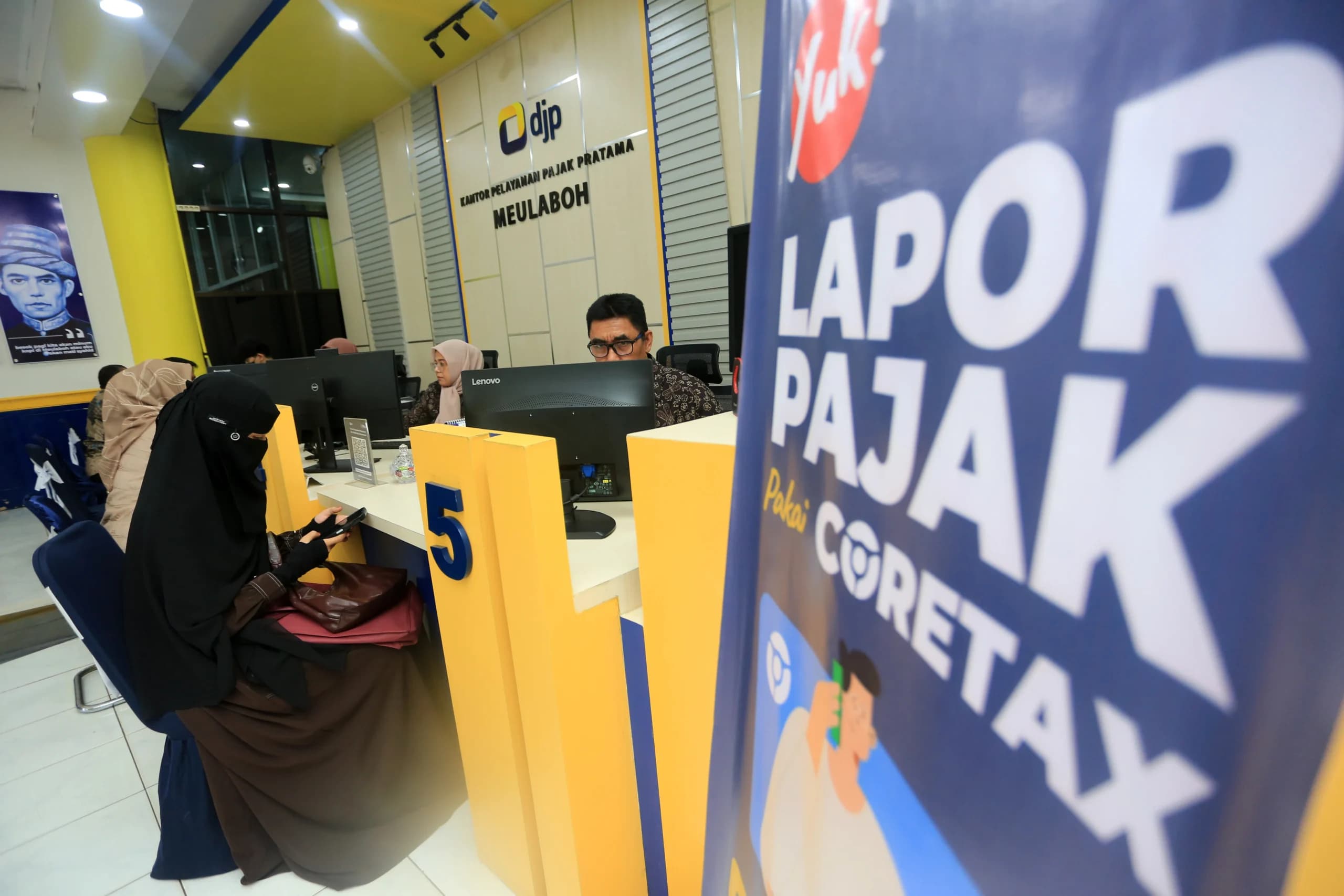 Petugas melayani peserta wajib pajak yang melaporkan SPT Tahunan Petugas melayani peserta wajib pajak yang melaporkan SPT Tahunan