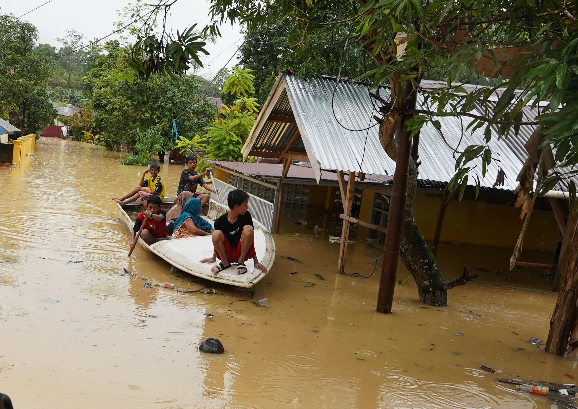 Warga menggunakan perahu saat melintas di depan rumah yang terendam banjir akibat meluapnya Kali Wanggu di Kelurahan Lepo-lepo, Kendari, Sulawesi Tenggara Warga menggunakan perahu saat melintas di depan rumah yang terendam banjir akibat meluapnya Kali Wanggu di Kelurahan Lepo-lepo, Kendari, Sulawesi Tenggara
