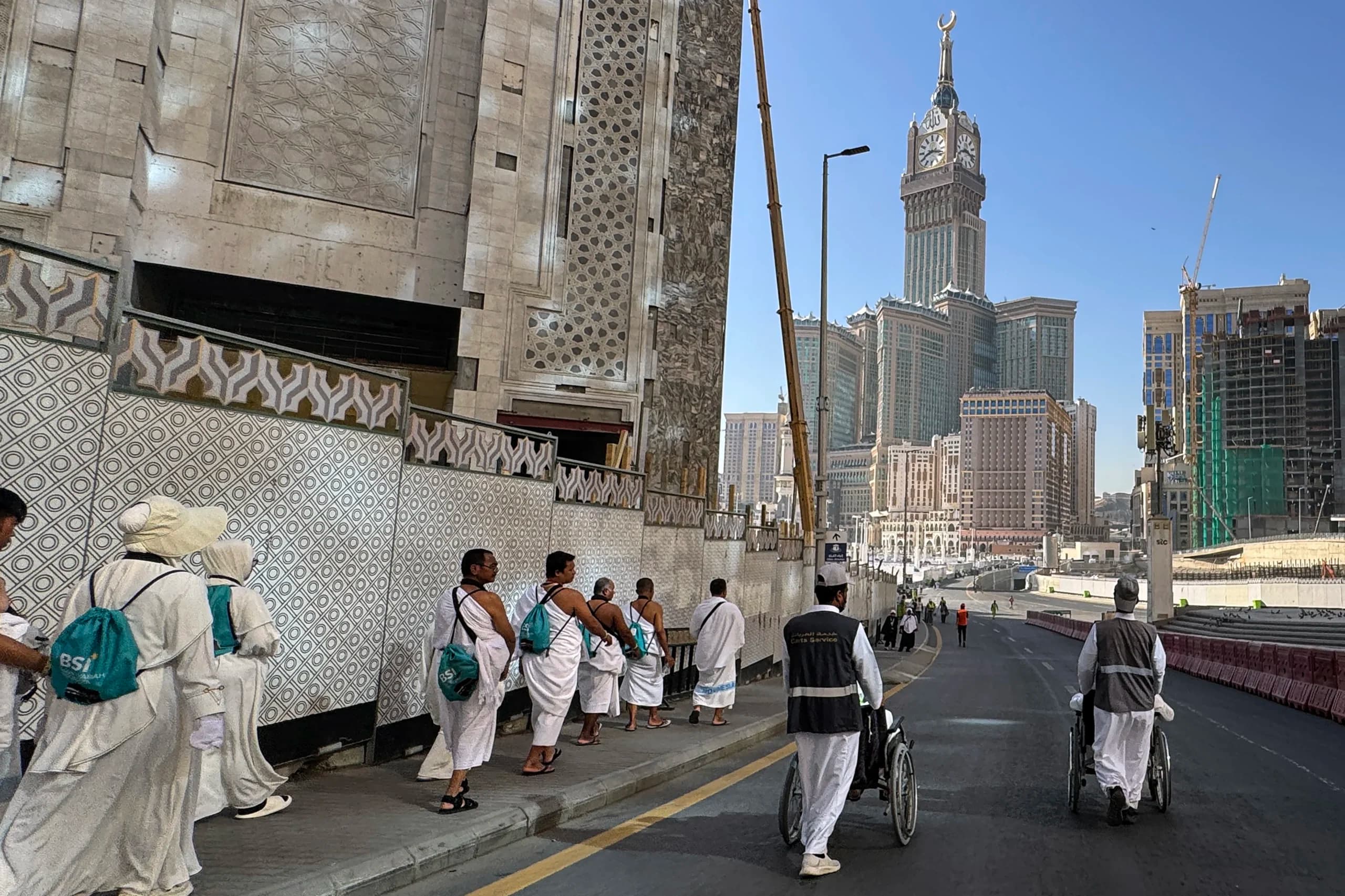 Petugas pendorong kursi roda melayani jamaah calon haji Indonesia menuju Masjidil Haram di Makkah, Arab Saudi Petugas pendorong kursi roda melayani jamaah calon haji Indonesia menuju Masjidil Haram di Makkah, Arab Saudi