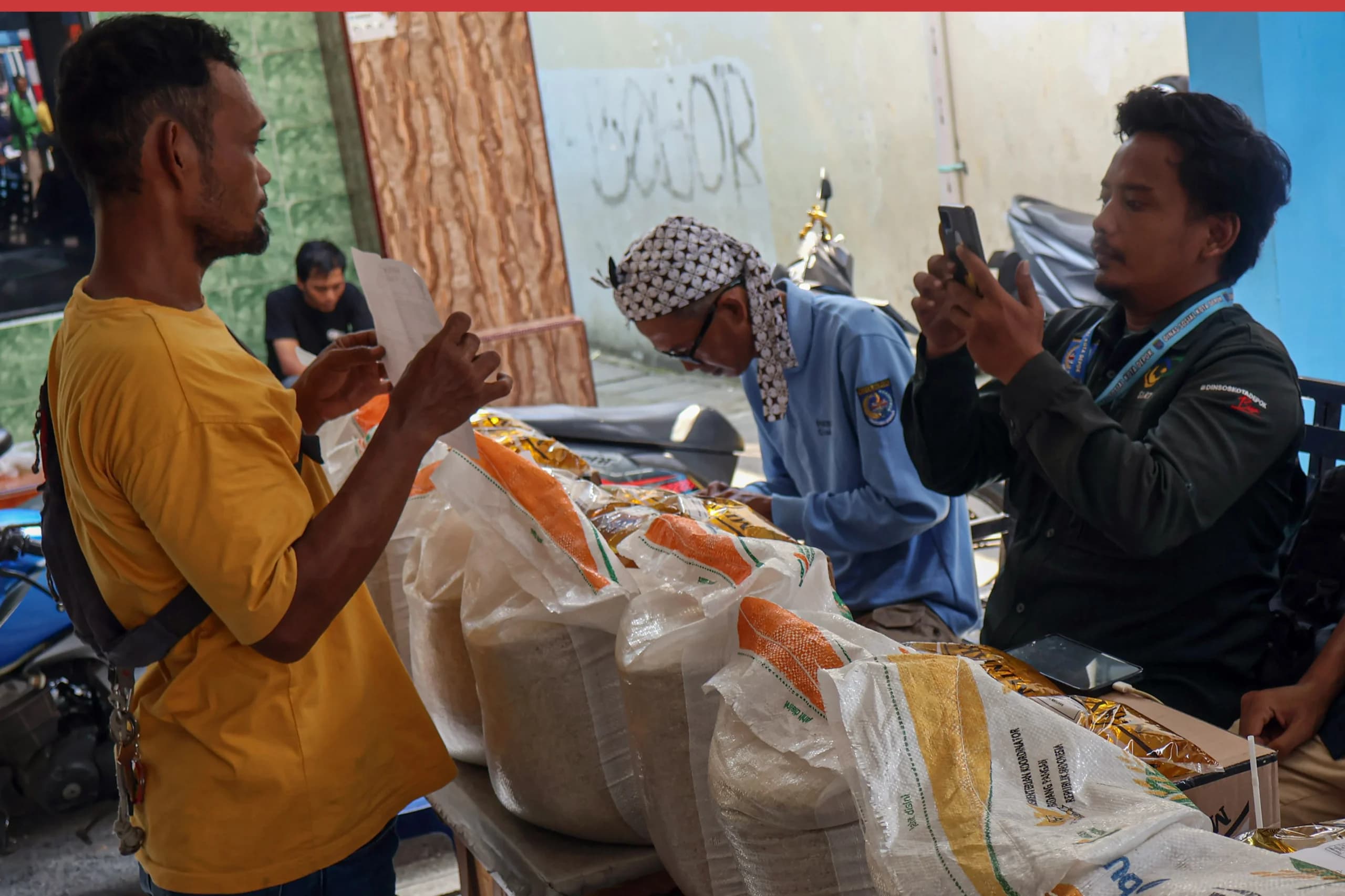 Petugas memotret identitas penerima bantuan sosial saat penyaluran beras dan MinyaKita di Kelurahan Sukamaju, Kota Depok, Jawa Barat Petugas memotret identitas penerima bantuan sosial saat penyaluran beras dan MinyaKita di Kelurahan Sukamaju, Kota Depok, Jawa Barat
