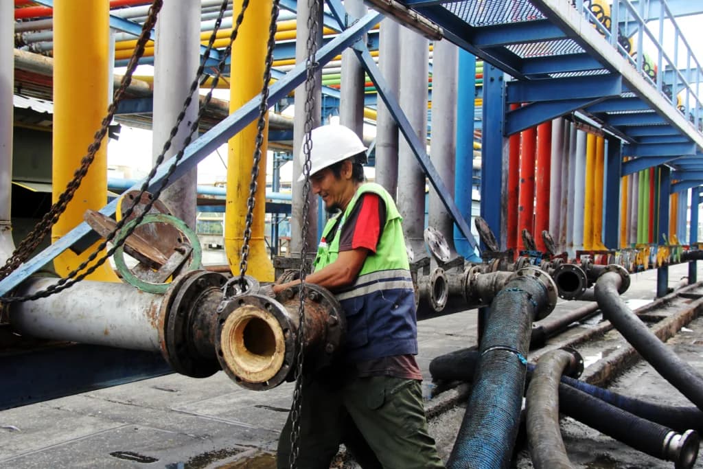 Seorang pekerja memasang sambungan pipa untuk proses pemindahan material crude palm oil (CPO) ke dalam kapal tanker di Dermaga B Curah Cair Pelabuhan PT Pelindo Multi Terminal (SPMT) Branch Dumai, Riau, Rabu (13/5/2026). Seorang pekerja memasang sambungan pipa untuk proses pemindahan material crude palm oil (CPO) ke dalam kapal tanker di Dermaga B Curah Cair Pelabuhan PT Pelindo Multi Terminal (SPMT) Branch Dumai, Riau, Rabu (13/5/2026).