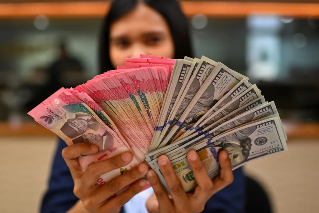 Karyawan memperlihatkan uang pecahan rupiah dan dolar Amerika Serikat (AS) di gerai penukaran mata uang asing Ayu Masagung, Jakarta. (Sumber: Antara Foto/Indrianto Eko Suwarso/kye) Karyawan memperlihatkan uang pecahan rupiah dan dolar Amerika Serikat (AS) di gerai penukaran mata uang asing Ayu Masagung, Jakarta. (Sumber: Antara Foto/Indrianto Eko Suwarso/kye)