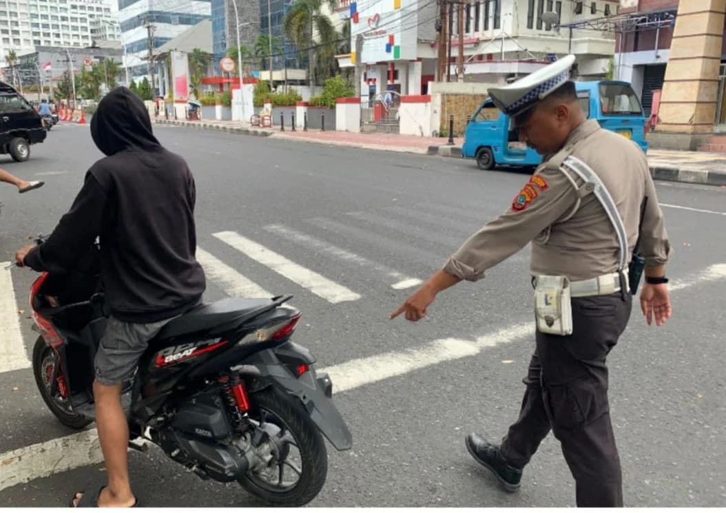 Petugas lalu lintas saat menegur pengendara motor. Petugas lalu lintas saat menegur pengendara motor.