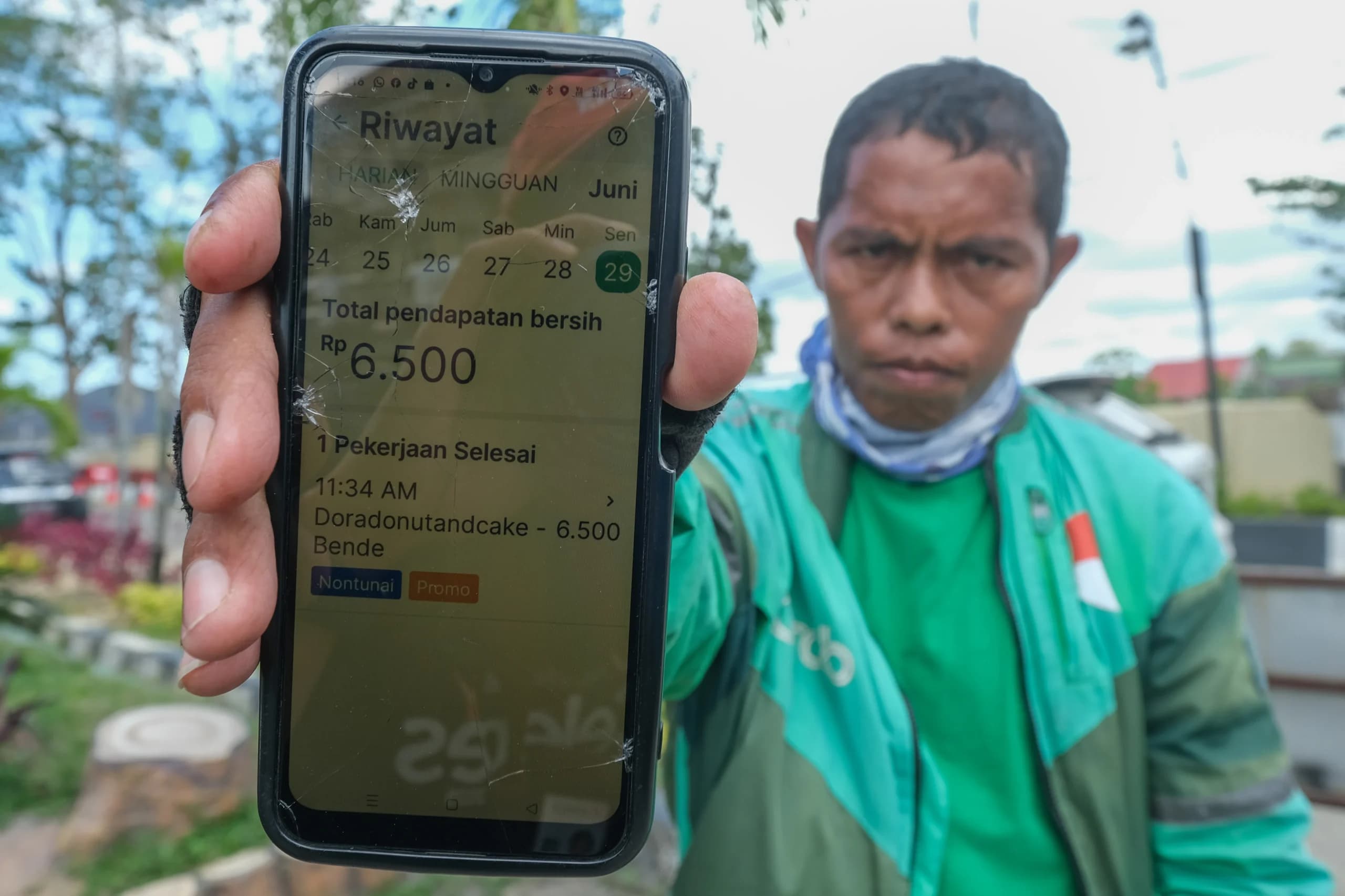 Seorang pengemudi ojek daring (ojol) menunjukkan riwayat pendapatannya di Kendari, Sulawesi Tenggara, Senin (29/6/2026). Seorang pengemudi ojek daring (ojol) menunjukkan riwayat pendapatannya di Kendari, Sulawesi Tenggara, Senin (29/6/2026).