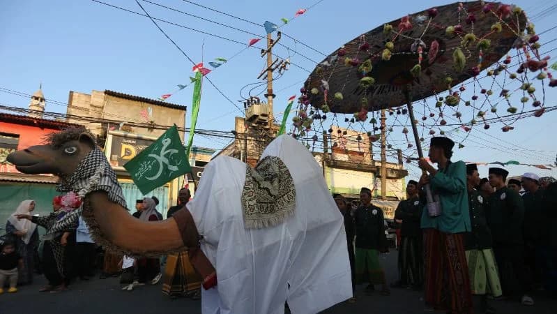 Peserta mengarak replika unta saat mengikuti pawai Maulid Nabi di Kampung Nelayan Nambangan-Cumpat, Surabaya. Peserta mengarak replika unta saat mengikuti pawai Maulid Nabi di Kampung Nelayan Nambangan-Cumpat, Surabaya.