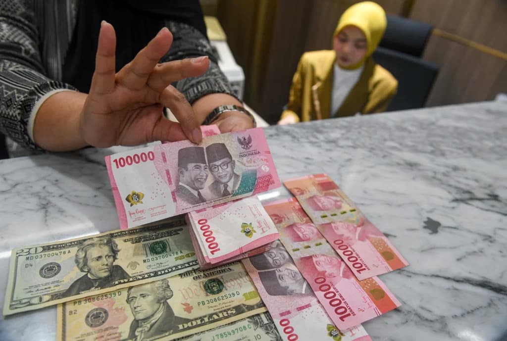 Petugas menunjukkan pecahan mata uang Rupiah dan Dolar AS di Kantor Cabang BNI Pasar Baru, Jakarta, Kamis (20/8/2026). Petugas menunjukkan pecahan mata uang Rupiah dan Dolar AS di Kantor Cabang BNI Pasar Baru, Jakarta, Kamis (20/8/2026).