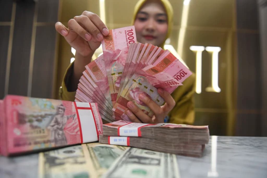 Petugas menunjukkan pecahan mata uang Rupiah dan Dolar AS di Kantor Cabang BNI Pasar Baru, Jakarta. (Sumber: Antara Foto/Muhammad Adimaja/nym) Petugas menunjukkan pecahan mata uang Rupiah dan Dolar AS di Kantor Cabang BNI Pasar Baru, Jakarta. (Sumber: Antara Foto/Muhammad Adimaja/nym)