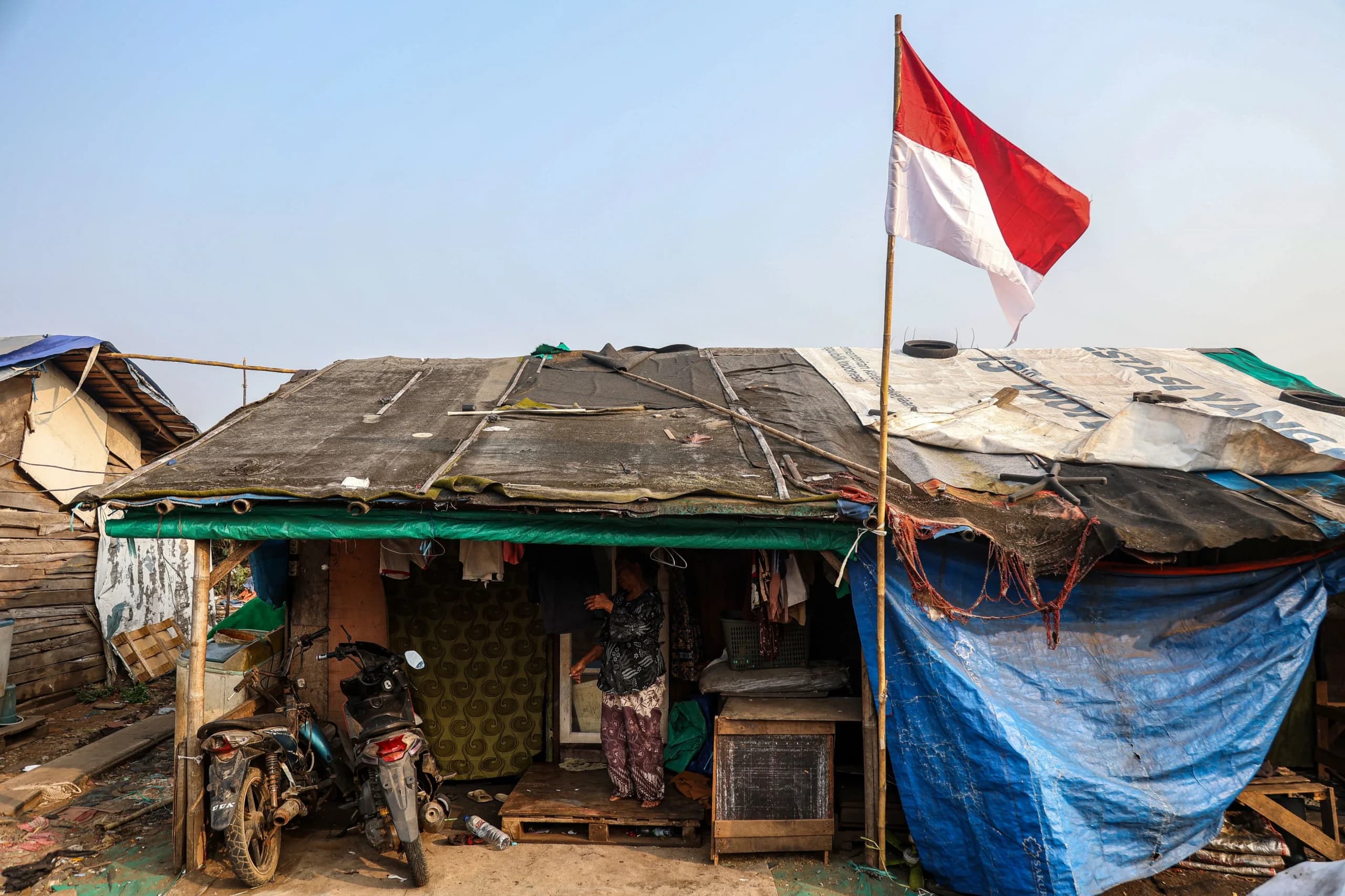 Seorang warga berdiri di depan rumahnya usai menjemur pakaian di Kampung Pemulung Cikiwul, Bantargebang, Kota Bekasi, Jawa Barat. (Sumber: Antara Foto/Darryl Ramadhan/tom) Seorang warga berdiri di depan rumahnya usai menjemur pakaian di Kampung Pemulung Cikiwul, Bantargebang, Kota Bekasi, Jawa Barat. (Sumber: Antara Foto/Darryl Ramadhan/tom)