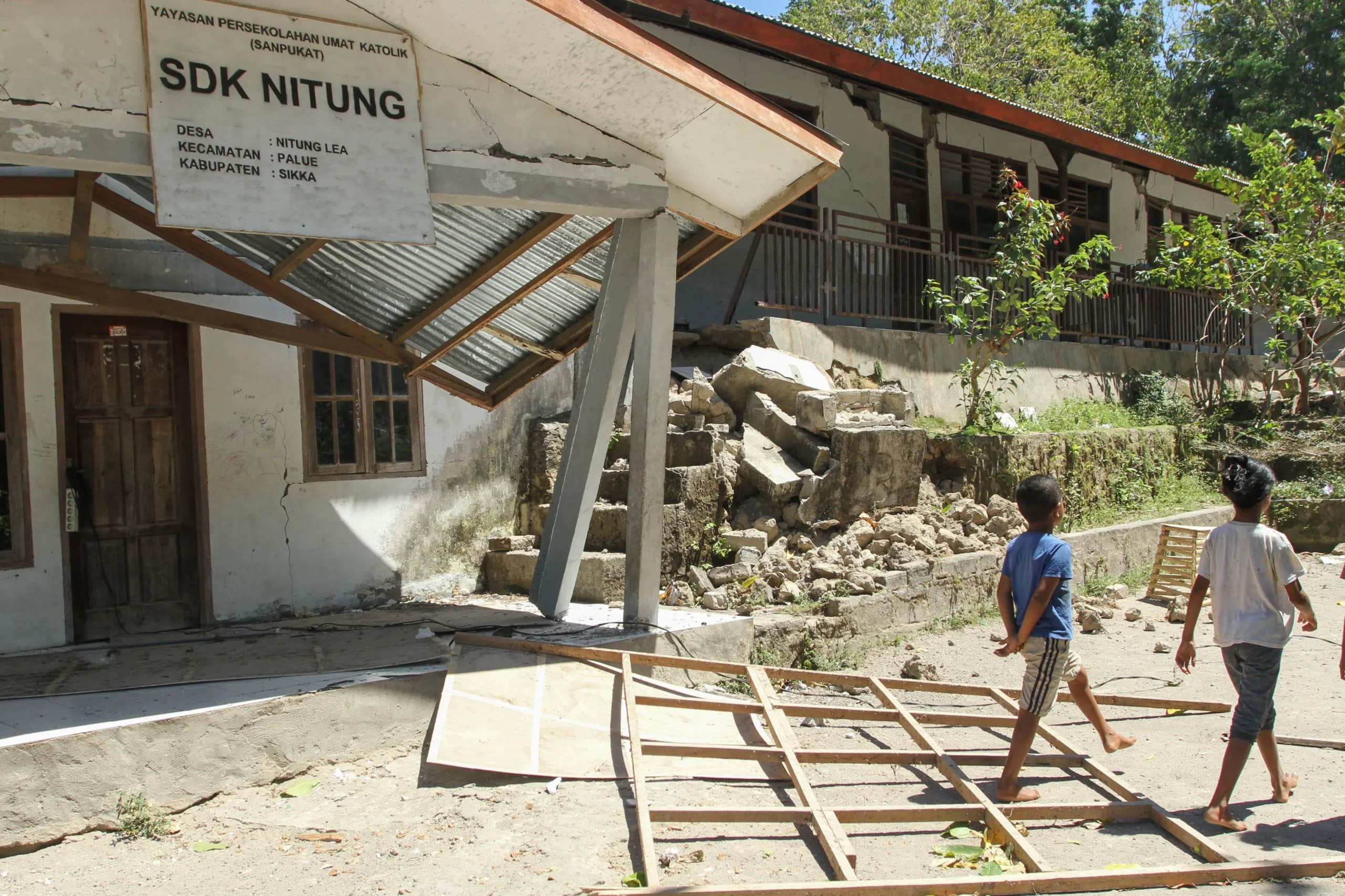 Warga melintas di samping bangunan sekolah yang rusak akibat gempa bumi magnitudo 7,7 di Pulau Palue, Kabupaten Sikka, NTT Warga melintas di samping bangunan sekolah yang rusak akibat gempa bumi magnitudo 7,7 di Pulau Palue, Kabupaten Sikka, NTT