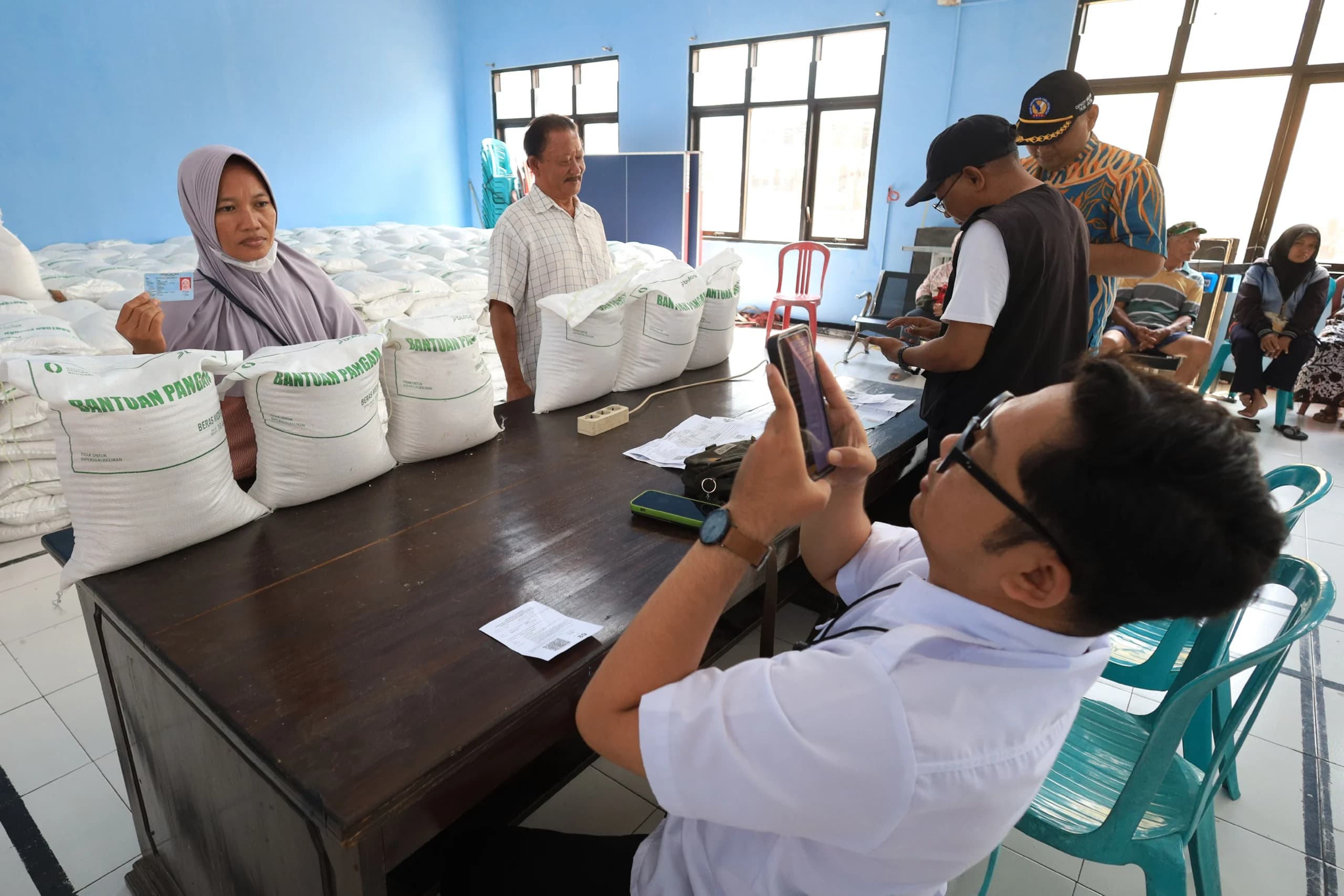 DPR RI menyoroti rencana pemerintah membuka hingga 200 juta rekening baru untuk memperkuat penyaluran bantuan sosial (bansos). Anggota Komisi VIII DPR RI Muhamad Abdul Azis Sefudin mempertanyakan dasar penetapan target tersebut karena jumlah masyarakat usia produktif yang belum memiliki rekening jauh lebih kecil. Azis menilai program pembukaan rekening secara massal perlu dikaji ulang agar anggaran yang disiapkan pemerintah benar-benar menjawab kebutuhan penerima bansos, bukan sekadar mengejar jumlah rekening yang dibuka. “Jangan sampai kita sibuk membuka rekening sebanyak-banyaknya, sementara persoalan siapa yang berhak menerima bansos belum selesai,” tegas Azis di Jakarta, Selasa, 15 September 2026. Sorotan itu muncul setelah pemerintah menyiapkan anggaran Rp11 triliun melalui bank-bank Himbara untuk mendukung pembukaan rekening secara massal. Azis kemudian membandingkan target tersebut dengan data Lembaga Penjamin Simpanan (LPS). Berdasarkan data yang dia soroti, jumlah masyarakat usia produktif di Indonesia yang belum memiliki rekening pada 2026 hanya sekitar 15,3 juta jiwa. Angka itu terpaut sangat jauh dengan target pembukaan 200 juta rekening baru. Karena itu, Azis meminta pemerintah menjelaskan secara terbuka siapa yang menjadi sasaran program tersebut dan apa dasar perhitungannya. “Pemerintah berkewajiban meyakinkan publik dan menjelaskan secara transparan apa urgensi dari target 200 juta rekening ini, serta siapa sebenarnya sasaran spesifik dari sisa kuota yang begitu besar,” tegas Azis. Menurut politikus Fraksi PDI Perjuangan itu, percepatan penyaluran bansos melalui perbankan pada dasarnya penting. Namun, skala program harus disesuaikan dengan kebutuhan riil penerima manfaat di lapangan. Dia mengingatkan pembukaan rekening baru secara besar-besaran juga berpotensi menimbulkan persoalan lain apabila rekening dibuat untuk warga yang sebenarnya sudah memiliki rekening perbankan. Kondisi tersebut, kata Azis, dapat memunculkan rekening ganda atau duplikasi yang pada akhirnya justru menambah jumlah rekening pasif atau dormant. “Jangan sampai anggaran besar justru habis untuk program administratif yang tidak efektif,” pungkasnya. Karena itu, Azis mendesak pemerintah membuka dasar perhitungan target 200 juta rekening sekaligus merinci penggunaan anggaran Rp11 triliun. Menurut dia, pemerintah perlu melakukan evaluasi cost-benefit sebelum program dijalankan dalam skala besar. “Pemerintah harus memastikan target pembukaan rekening ini benar-benar sesuai dengan kebutuhan riil penerima bansos agar tidak terjadi pemborosan anggaran akibat rekening ganda,” kata Azis. Azis menilai persoalan yang lebih mendesak justru berada pada kualitas data penerima bansos. Pemerintah perlu memastikan Data Tunggal Sosial Ekonomi Nasional (DTSEN), validitas NIK, pemutakhiran data, dan integrasi antar-lembaga berjalan dengan baik agar bantuan benar-benar diterima masyarakat yang berhak. “Fokus utama dan prioritas alokasi anggaran seharusnya tetap dicurahkan pada peningkatan kualitas Data Tunggal Sosial Ekonomi Nasional (DTSEN), validitas NIK, pemutakhiran data, serta integrasi antar-lembaga demi menjamin ketepatan sasaran bansos,” pungkasnya. Petugas melakukan perekaman data saat penyaluran bantuan pangan beras di Kelurahan Burengan, Kota Kediri, Jawa Timur, Rabu (26/8/2026). DPR RI menyoroti rencana pemerintah membuka hingga 200 juta rekening baru untuk memperkuat penyaluran bantuan sosial (bansos). Anggota Komisi VIII DPR RI Muhamad Abdul Azis Sefudin mempertanyakan dasar penetapan target tersebut karena jumlah masyarakat usia produktif yang belum memiliki rekening jauh lebih kecil. Azis menilai program pembukaan rekening secara massal perlu dikaji ulang agar anggaran yang disiapkan pemerintah benar-benar menjawab kebutuhan penerima bansos, bukan sekadar mengejar jumlah rekening yang dibuka. “Jangan sampai kita sibuk membuka rekening sebanyak-banyaknya, sementara persoalan siapa yang berhak menerima bansos belum selesai,” tegas Azis di Jakarta, Selasa, 15 September 2026. Sorotan itu muncul setelah pemerintah menyiapkan anggaran Rp11 triliun melalui bank-bank Himbara untuk mendukung pembukaan rekening secara massal. Azis kemudian membandingkan target tersebut dengan data Lembaga Penjamin Simpanan (LPS). Berdasarkan data yang dia soroti, jumlah masyarakat usia produktif di Indonesia yang belum memiliki rekening pada 2026 hanya sekitar 15,3 juta jiwa. Angka itu terpaut sangat jauh dengan target pembukaan 200 juta rekening baru. Karena itu, Azis meminta pemerintah menjelaskan secara terbuka siapa yang menjadi sasaran program tersebut dan apa dasar perhitungannya. “Pemerintah berkewajiban meyakinkan publik dan menjelaskan secara transparan apa urgensi dari target 200 juta rekening ini, serta siapa sebenarnya sasaran spesifik dari sisa kuota yang begitu besar,” tegas Azis. Menurut politikus Fraksi PDI Perjuangan itu, percepatan penyaluran bansos melalui perbankan pada dasarnya penting. Namun, skala program harus disesuaikan dengan kebutuhan riil penerima manfaat di lapangan. Dia mengingatkan pembukaan rekening baru secara besar-besaran juga berpotensi menimbulkan persoalan lain apabila rekening dibuat untuk warga yang sebenarnya sudah memiliki rekening perbankan. Kondisi tersebut, kata Azis, dapat memunculkan rekening ganda atau duplikasi yang pada akhirnya justru menambah jumlah rekening pasif atau dormant. “Jangan sampai anggaran besar justru habis untuk program administratif yang tidak efektif,” pungkasnya. Karena itu, Azis mendesak pemerintah membuka dasar perhitungan target 200 juta rekening sekaligus merinci penggunaan anggaran Rp11 triliun. Menurut dia, pemerintah perlu melakukan evaluasi cost-benefit sebelum program dijalankan dalam skala besar. “Pemerintah harus memastikan target pembukaan rekening ini benar-benar sesuai dengan kebutuhan riil penerima bansos agar tidak terjadi pemborosan anggaran akibat rekening ganda,” kata Azis. Azis menilai persoalan yang lebih mendesak justru berada pada kualitas data penerima bansos. Pemerintah perlu memastikan Data Tunggal Sosial Ekonomi Nasional (DTSEN), validitas NIK, pemutakhiran data, dan integrasi antar-lembaga berjalan dengan baik agar bantuan benar-benar diterima masyarakat yang berhak. “Fokus utama dan prioritas alokasi anggaran seharusnya tetap dicurahkan pada peningkatan kualitas Data Tunggal Sosial Ekonomi Nasional (DTSEN), validitas NIK, pemutakhiran data, serta integrasi antar-lembaga demi menjamin ketepatan sasaran bansos,” pungkasnya. Petugas melakukan perekaman data saat penyaluran bantuan pangan beras di Kelurahan Burengan, Kota Kediri, Jawa Timur, Rabu (26/8/2026).
