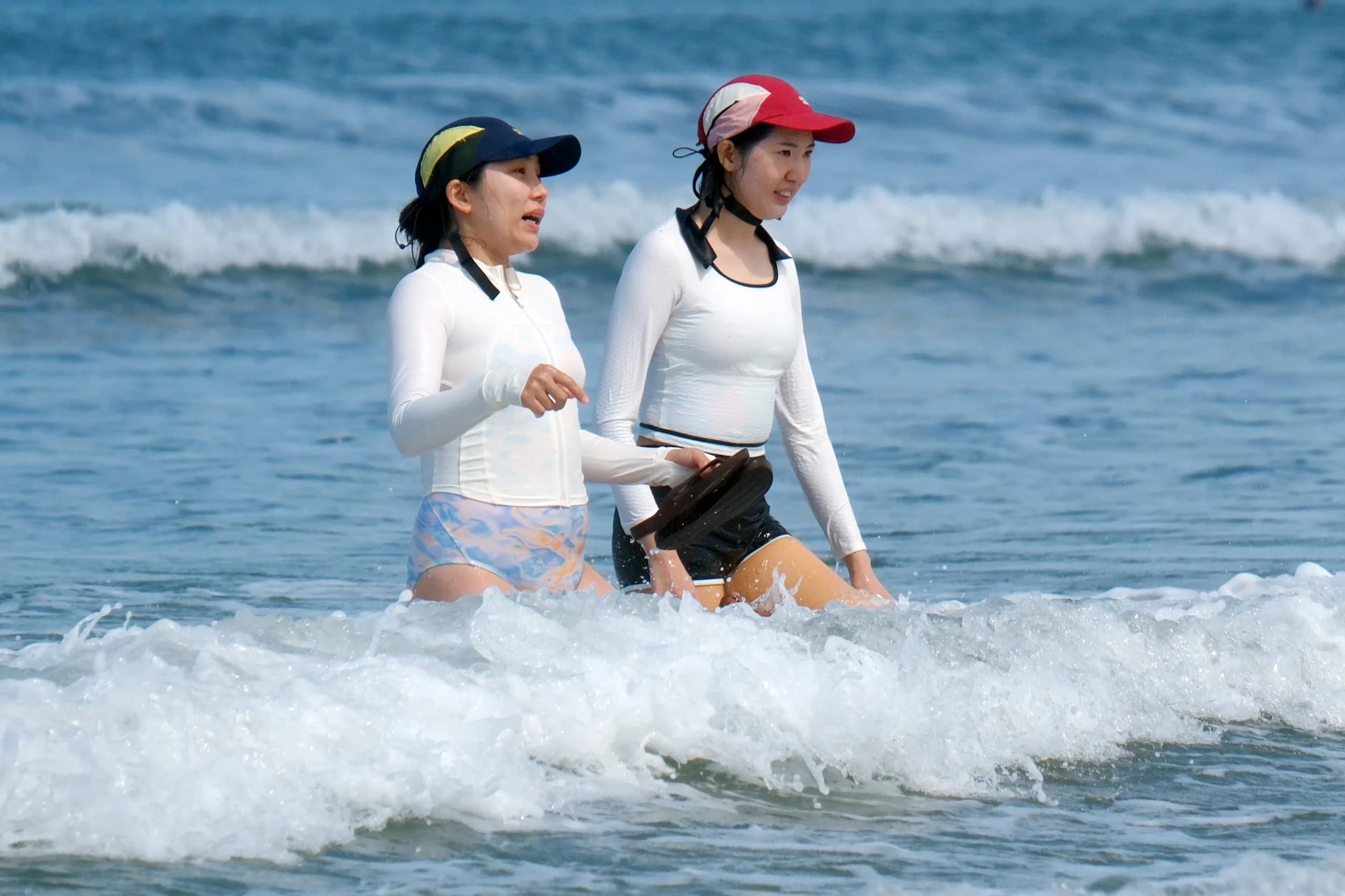 Wisatawan mancanegara berjalan di tengah ombak saat berkunjung di Pantai Kuta, Badung, Bali, Rabu (16/9/2026). Wisatawan mancanegara berjalan di tengah ombak saat berkunjung di Pantai Kuta, Badung, Bali, Rabu (16/9/2026).