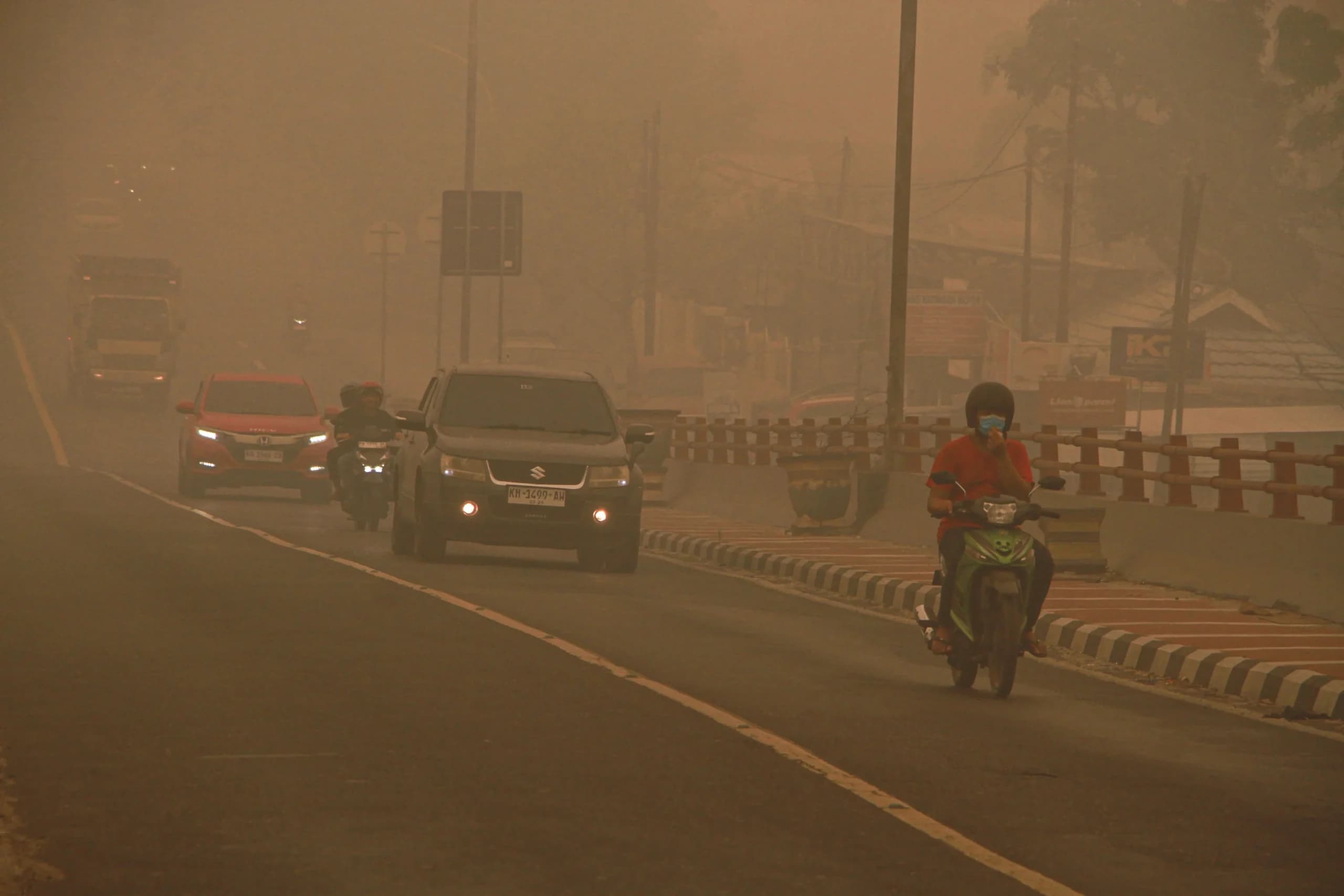 Pengendara motor melintas di Jembatan Kahayan yang diselimuti asap di Palangka Raya, Kalimantan Tengah Pengendara motor melintas di Jembatan Kahayan yang diselimuti asap di Palangka Raya, Kalimantan Tengah