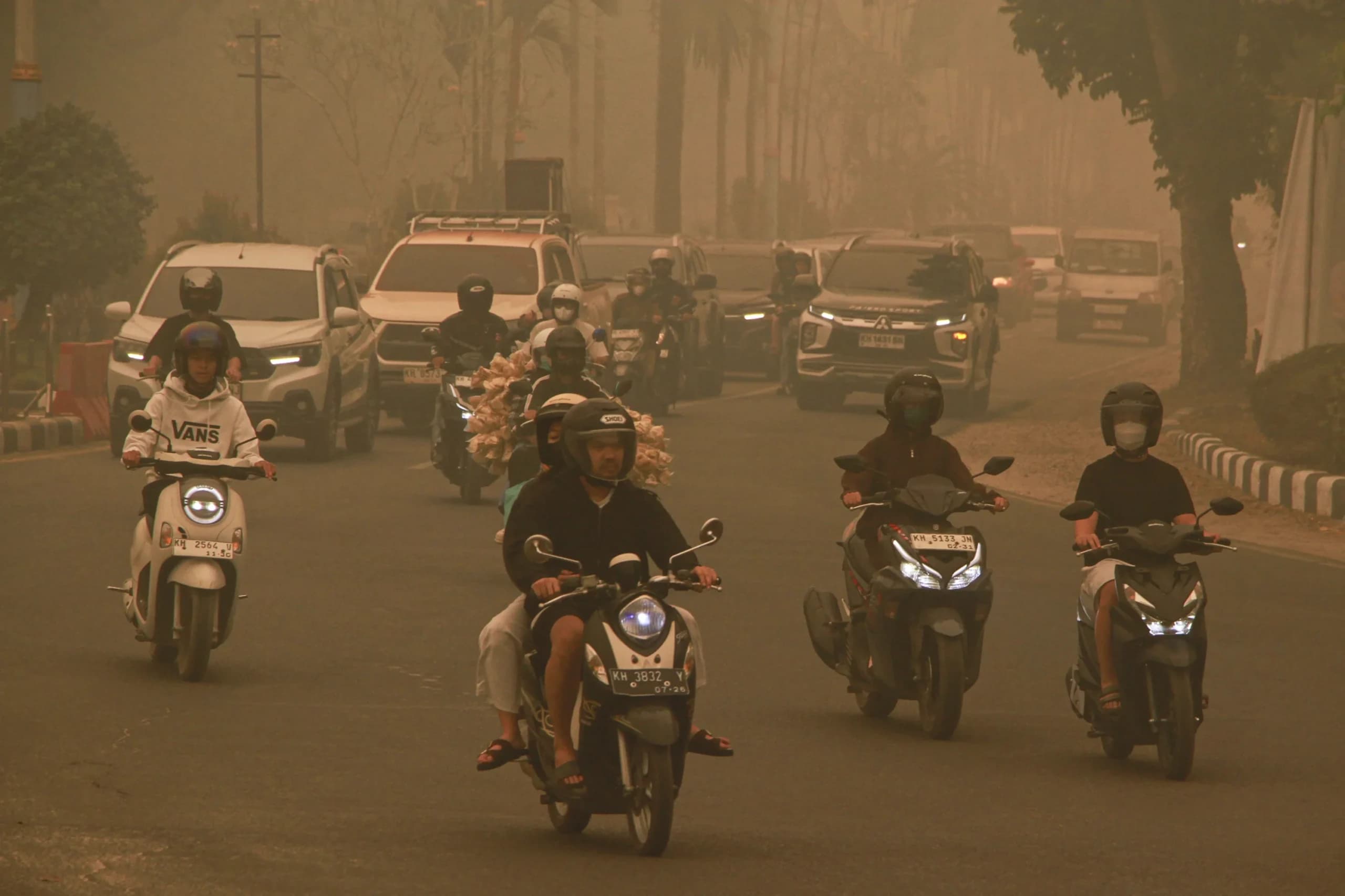 Sejumlah pengendara motor melintasi Bundaran Burung saat kabut asap di Palangka Raya, Kalimantan Tengah Sejumlah pengendara motor melintasi Bundaran Burung saat kabut asap di Palangka Raya, Kalimantan Tengah