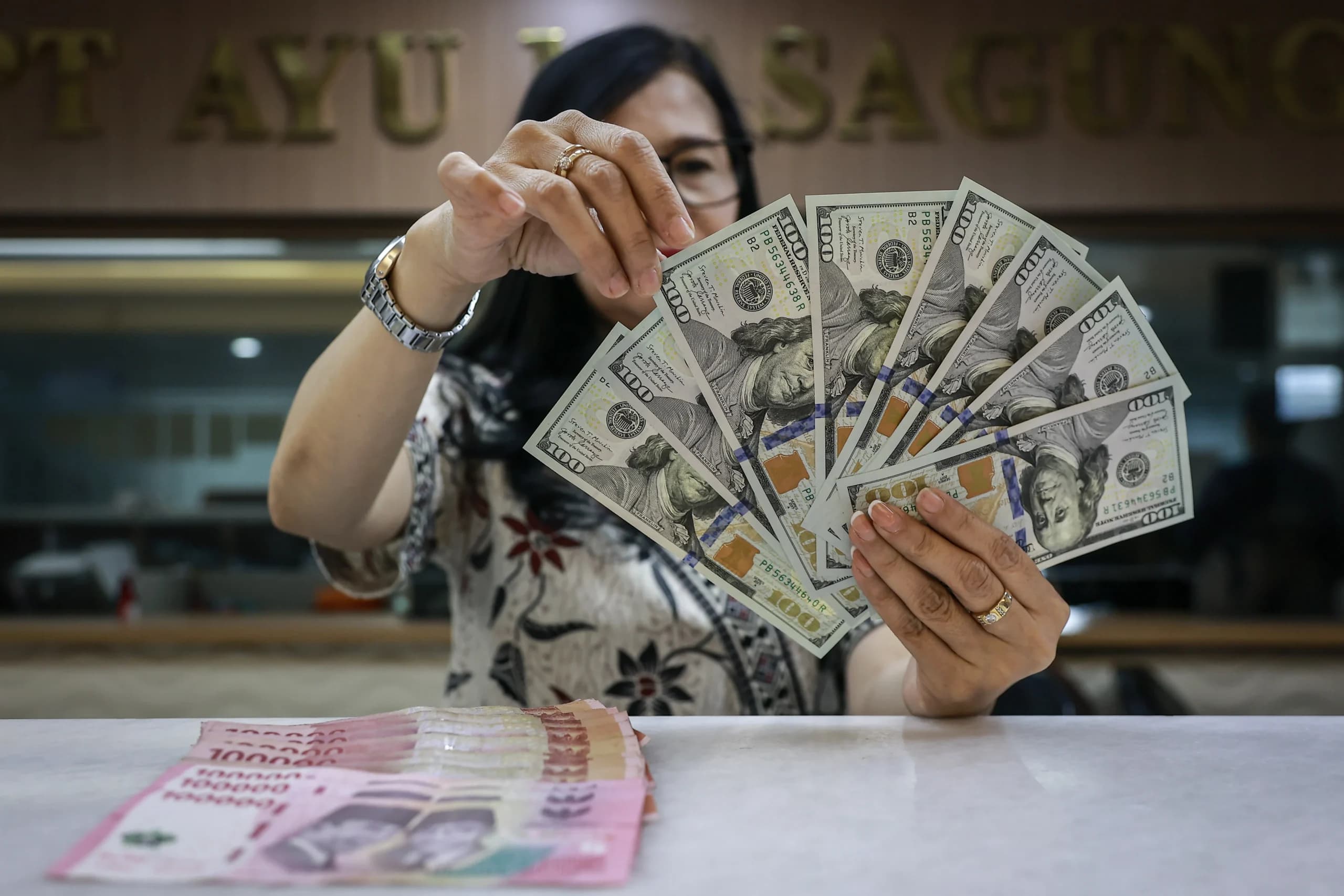 Karyawan menghitung uang pecahan dolar Amerika Serikat (AS) dan rupiah di gerai penukaran mata uang asing Ayu Masagung, Jakarta, Jumat (16/10/2026). Karyawan menghitung uang pecahan dolar Amerika Serikat (AS) dan rupiah di gerai penukaran mata uang asing Ayu Masagung, Jakarta, Jumat (16/10/2026).