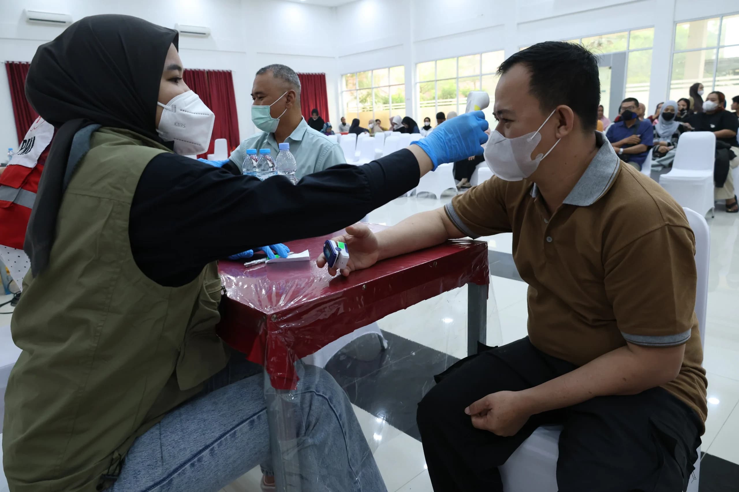 Tenaga kesehatan mengukur suhu tubuh warga dalam layanan pemeriksaan kesehatan gratis di PMI Provinsi Kalimantan Barat di Pontianak, Kalimantan Barat Tenaga kesehatan mengukur suhu tubuh warga dalam layanan pemeriksaan kesehatan gratis di PMI Provinsi Kalimantan Barat di Pontianak, Kalimantan Barat