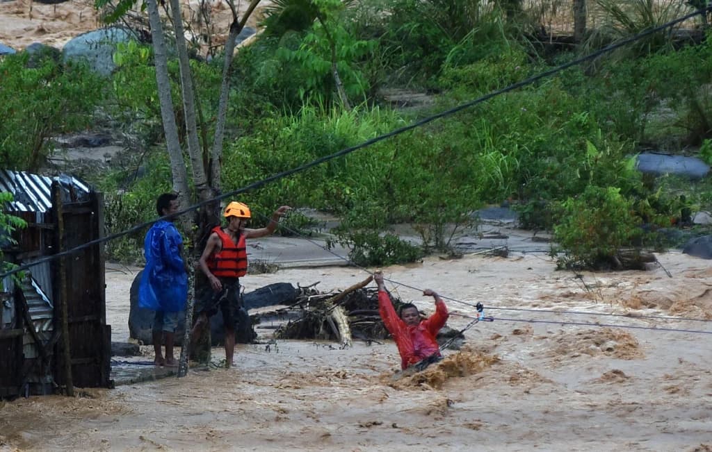 Tim SAR memandu warga menyeberangi air menggunakan tali di kawasan Batu Busuk, Pauh, Padang, Sumatera Barat, Minggu (14/12/2025). (Sumber: Antara Foto/Iggoy el Fitra/agr) Tim SAR memandu warga menyeberangi air menggunakan tali di kawasan Batu Busuk, Pauh, Padang, Sumatera Barat, Minggu (14/12/2025). (Sumber: Antara Foto/Iggoy el Fitra/agr)