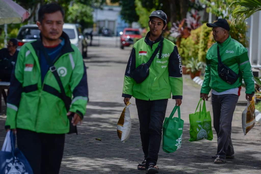 Pengemudi ojek online membawa paket sembako yang mereka terima di Kota Serang, Banten, Jumat (28/11/2025). Pengemudi ojek online membawa paket sembako yang mereka terima di Kota Serang, Banten, Jumat (28/11/2025).