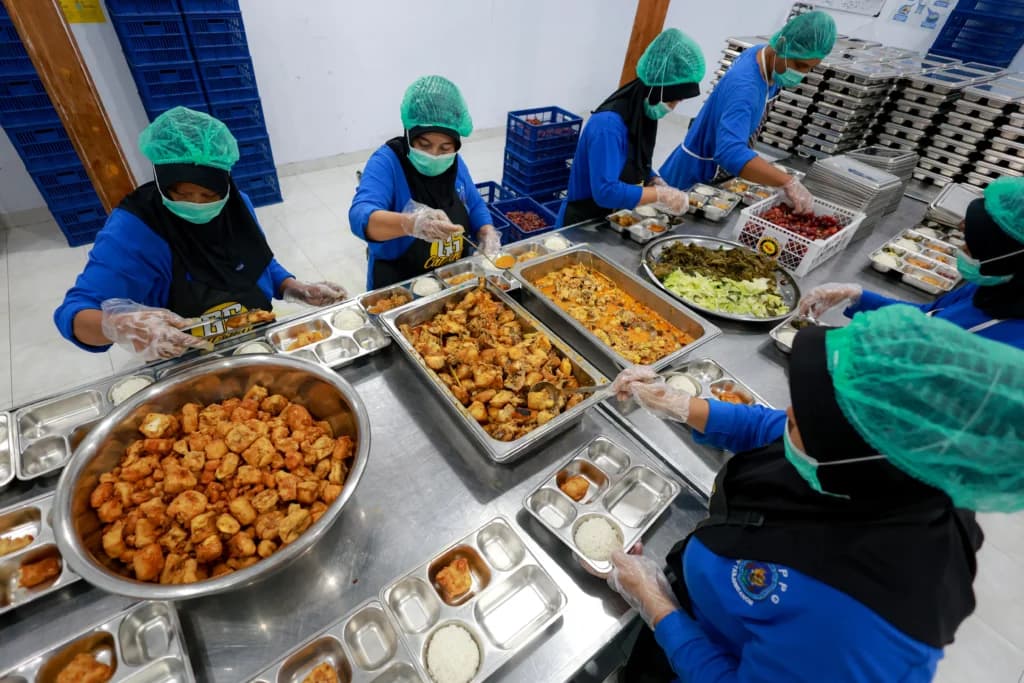 Sejumlah pekerja menyiapkan paket makanan untuk program makan bergizi gratis (MBG) di dapur Satuan Pelayanan Pemenuhan Gizi (SPPG) Dipan Tanjunganom, Nganjuk, Jawa Timur. Sejumlah pekerja menyiapkan paket makanan untuk program makan bergizi gratis (MBG) di dapur Satuan Pelayanan Pemenuhan Gizi (SPPG) Dipan Tanjunganom, Nganjuk, Jawa Timur.
