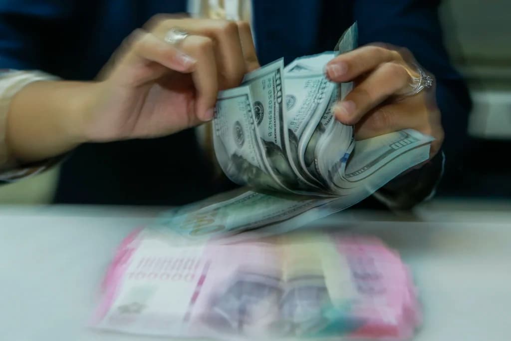 Karyawan menghitung uang pecahan rupiah dan dolar Amerika Serikat (AS) di gerai penukaran mata uang asing Ayu Masagung, Jakarta. (Sumber: Asprilla Dwi Adha/hma) Karyawan menghitung uang pecahan rupiah dan dolar Amerika Serikat (AS) di gerai penukaran mata uang asing Ayu Masagung, Jakarta. (Sumber: Asprilla Dwi Adha/hma)