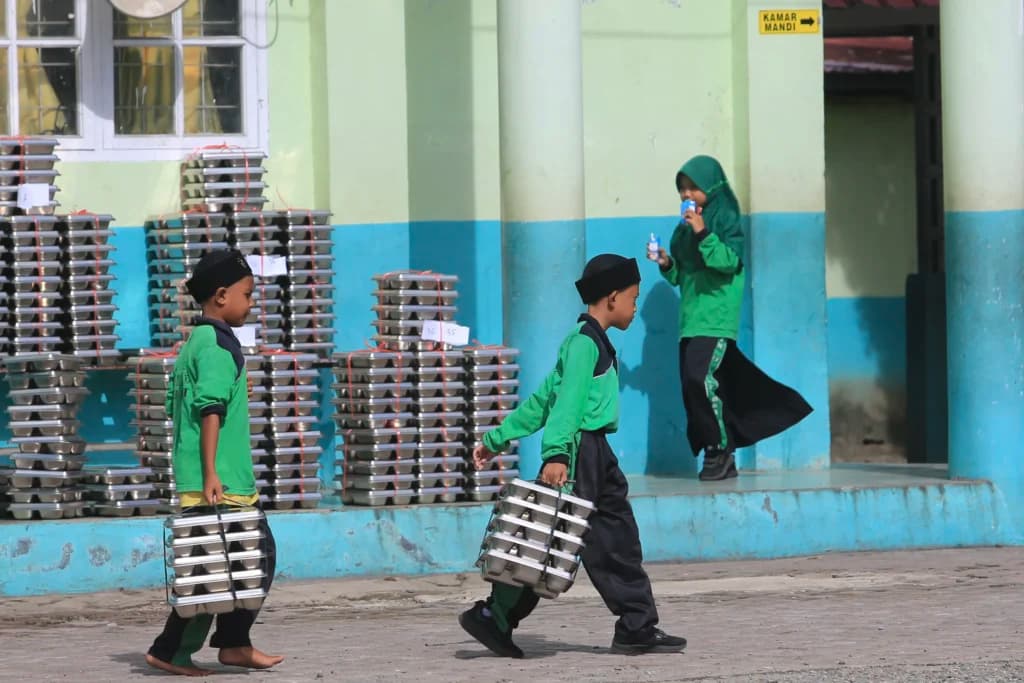 Sejumlah siswa membawa ompreng Makan Bergizi Gratis (MBG) di komplek Madrasah Ibtidayyah Negeri (MIN) 11 Aceh Barat dan Madrasah Tsanawiyah Swasta (MTS) Harapan Bangsa Desa Kuta Padang, Johan Pahlawan, Aceh Barat, Aceh, Rabu (20/5/2026). Sejumlah siswa membawa ompreng Makan Bergizi Gratis (MBG) di komplek Madrasah Ibtidayyah Negeri (MIN) 11 Aceh Barat dan Madrasah Tsanawiyah Swasta (MTS) Harapan Bangsa Desa Kuta Padang, Johan Pahlawan, Aceh Barat, Aceh, Rabu (20/5/2026).