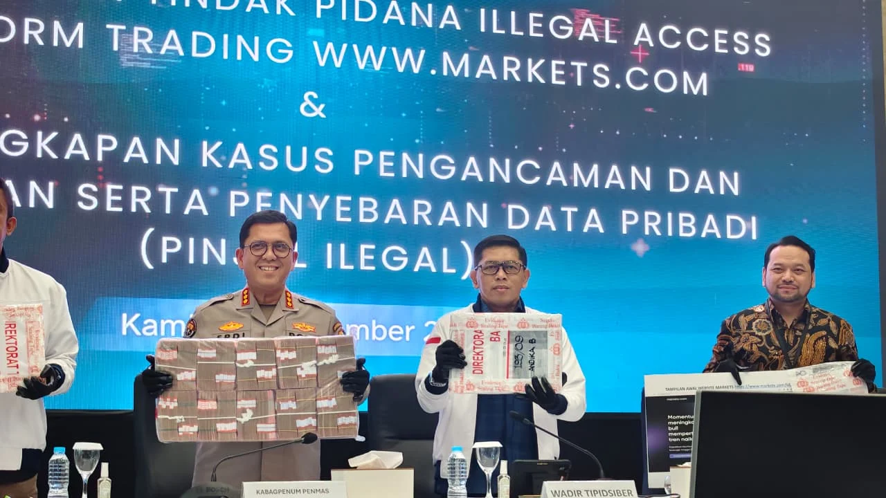 Wadirresiber Bareskrim Polri Kombes Pol Andri Sudarmadi memegang barang bukti kasus pengancaman dari pinjol ilegal.