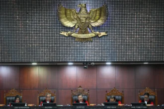 Ketua Mahkamah Konstitusi (MK) Suhartoyo (tengah) didampingi Wakil Ketua MK Saldi Isra (kedua kiri), anggota Majelis Hakim MK Arief Hidayat (kedua kanan), Daniel Yusmic P. Foekh (kanan) dan Enny Nurbaningsih (kiri) membacakan putusan uji materiil UU Polri di Gedung MK, Jakarta, Kamis (13/11/2025). MK mengabulkan uji materiil terhadap pasal 28 ayat (3) UU No. 2 tahun 2002 tentang Kepolisian Negara Republik Indonesia sehingga kini anggota Polri aktif harus mengundurkan diri atau pensiun untuk menduduki jabatan di luar kepolisian.
