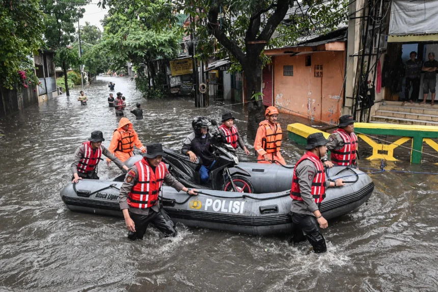 Personel polisi membantu warga mengevakuasi sepeda motor saat banjir di Kompleks Polri Pondok Karya, Mampang Prapatan, Jakarta, Selasa (18/11/2025). Badan Penanggulangan Bencana Daerah DKI Jakarta mencatat terdapat 13 RT di Jakarta Selatan yang tergenang banjir dengan ketinggian 30-80 centimeter akibat luapan air kali sebagai dampak dari tingginya intensitas hujan.