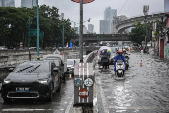 Kendaraan menerobos banjir di Jalan Terusan H. R. Rasuna Said, Jakarta, Selasa