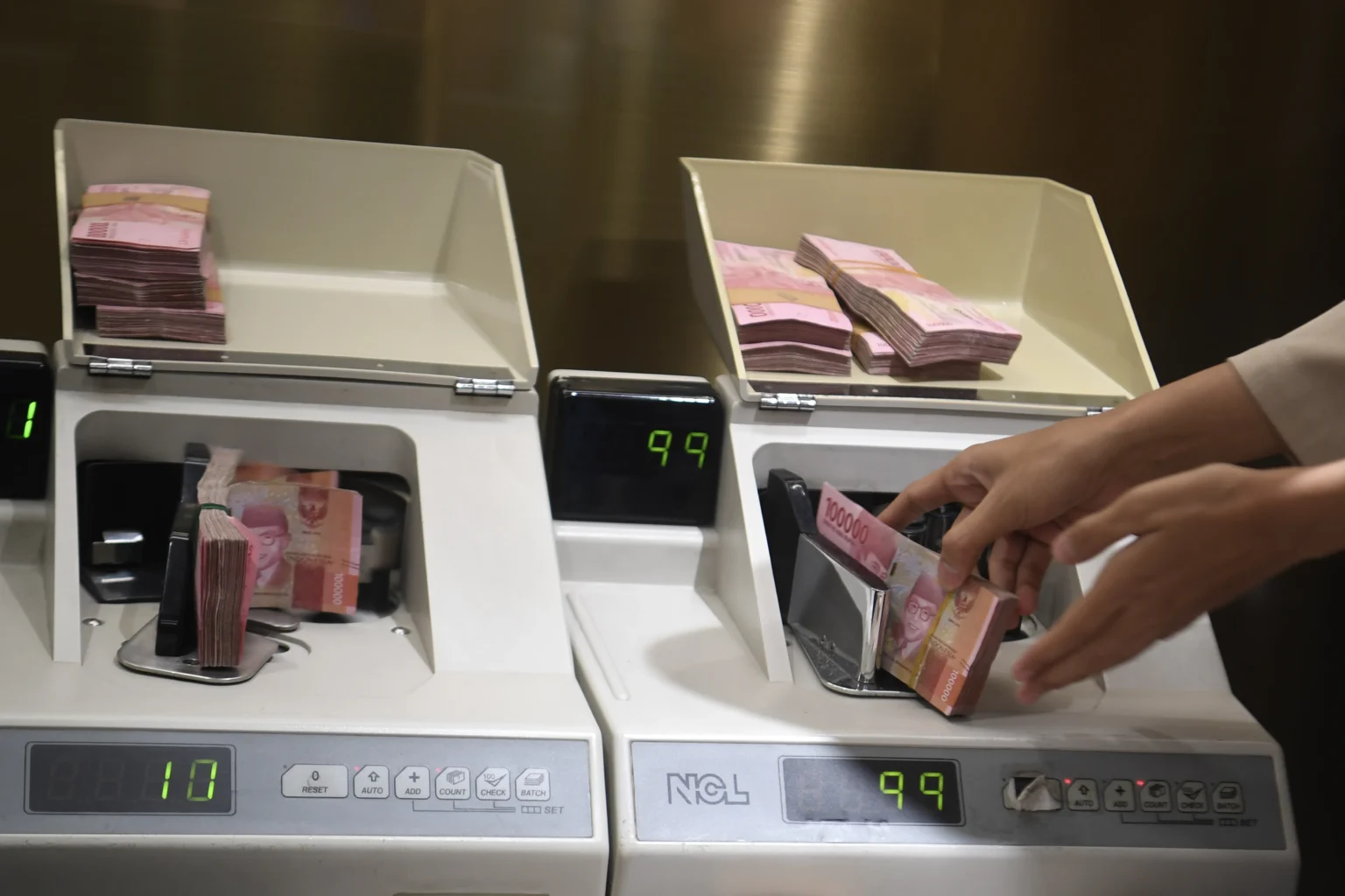 Petugas menghitung uang rupiah di Kantor Cabang BNI Pasar Baru