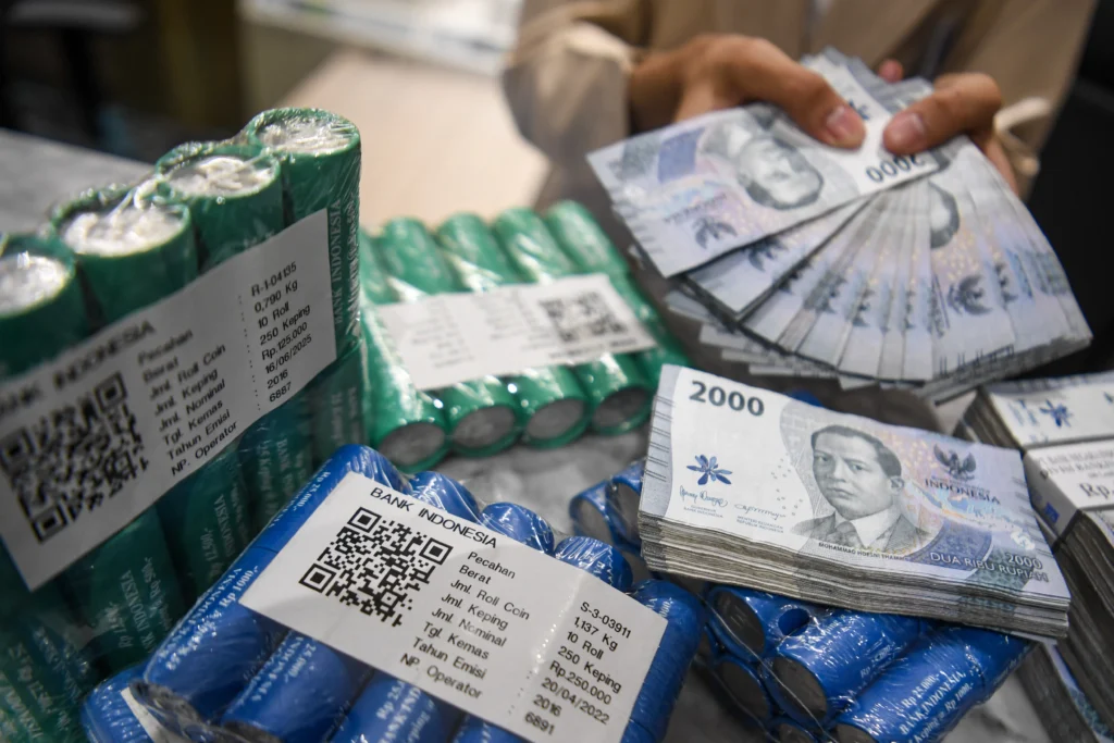 Petugas menunjukkan uang rupiah. (Sumber: Antara Foto/Muhammad Adimaja/nym