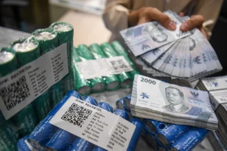 Petugas menunjukkan uang rupiah