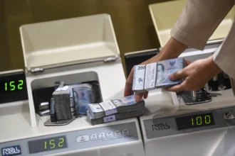 Petugas menghitung uang rupiah di Kantor Cabang BNI Pasar Baru, Jakarta
