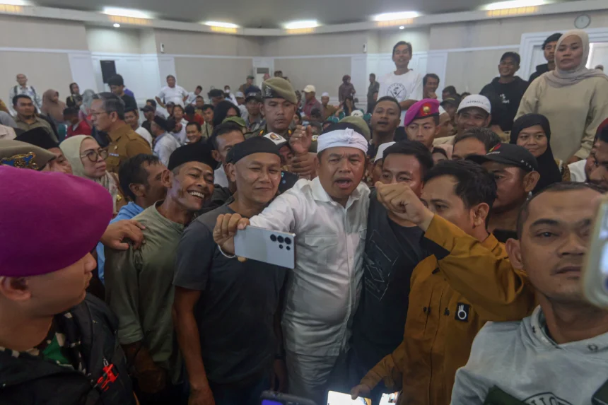 Gubernur Jawa Barat Dedi Mulyadi (tengah) berfoto dengan warga terdampak penutupan operasional tambang saat pemberian bantuan di Cibinong, Kabupaten Bogor, Jawa Barat, Senin (3/11/2025). Pemerintah Provinsi Jawa Barat mulai menyalurkan dana kompensasi sebesar Rp3 juta kepada 9.300 warga di wilayah Cigudeg, Rumpin, dan Parung Panjang di Kabupaten Bogor yang terdampak kebijakan penutupan tambang, kebijakan ini diharapkan dapat meringankan beban masyarakat sekaligus menjadi langkah awal pemulihan ekonomi setelah penutupan tambang diberlakukan.