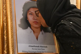 Adik aktivis buruh Marsinah, Wijiyati mencium foto kakaknya