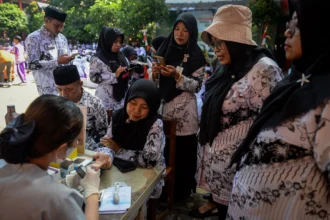 Tenaga kesehatan memeriksa kadar gula darah guru saat peringatan Hari Guru Nasional