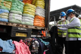 Menteri Perdagangan Budi Santoso (kedua kanan) bersama Anggota Komisi VI DPR Darmadi Durianto (kanan) melihat pakaian bekas impor sebelum dimusnahkan di PT Prasadha Pamunah Limbah Industri (PPLI), Klapanunggal, Bogor, Jawa Barat, Jumat (14/11/2025). Kementerian Perdagangan memusnahkan sebanyak 500 balpres dari total 19.391 balpres pakaian bekas impor atau thrifting dengan nilai sekitar Rp112,35 miliar yang merupakan hasil sitaan oleh Kemendag, Badan Intelijen Strategis Tentara Nasional Indonesia (BAIS TNI), Badan Intelijen Negara (BIN) dan Polri.
