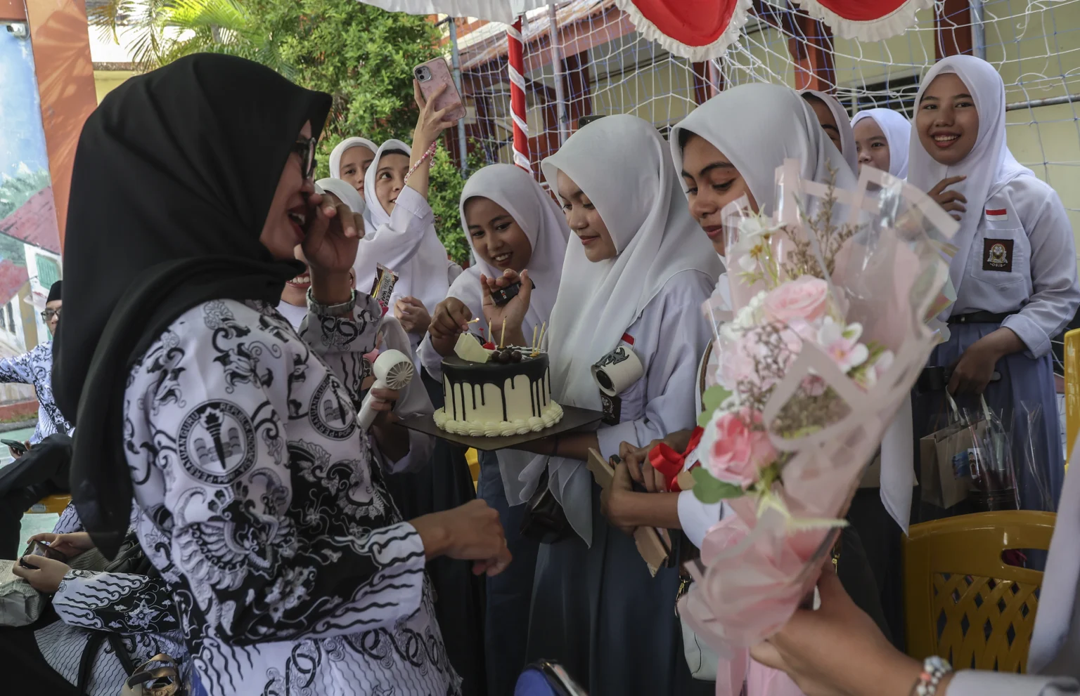 Sejumlah siswa memberikan kue ucapan selamat kepada gurunya saat perayaan peringatan Hari Guru di SMA Negeri 1 Ternate, Maluku Utara, Selasa (25/11/2025). Kegiatan yang mengusung tema Guru Hebat, Indonesia Kuat tersebut sebagai ungkapan rasa kasih sayang dan terima kasih dari murid kepada guru dalam memperingati Hari Guru Nasional 2025.