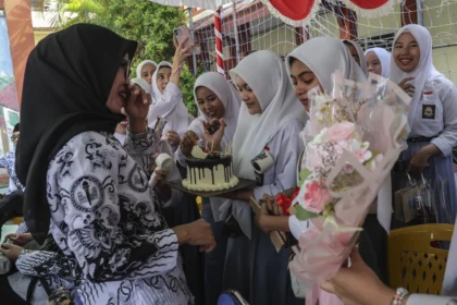 Sejumlah siswa memberikan kue ucapan selamat kepada gurunya saat perayaan peringatan Hari Guru di SMA Negeri 1 Ternate, Maluku Utara, Selasa (25/11/2025). Kegiatan yang mengusung tema Guru Hebat, Indonesia Kuat tersebut sebagai ungkapan rasa kasih sayang dan terima kasih dari murid kepada guru dalam memperingati Hari Guru Nasional 2025.