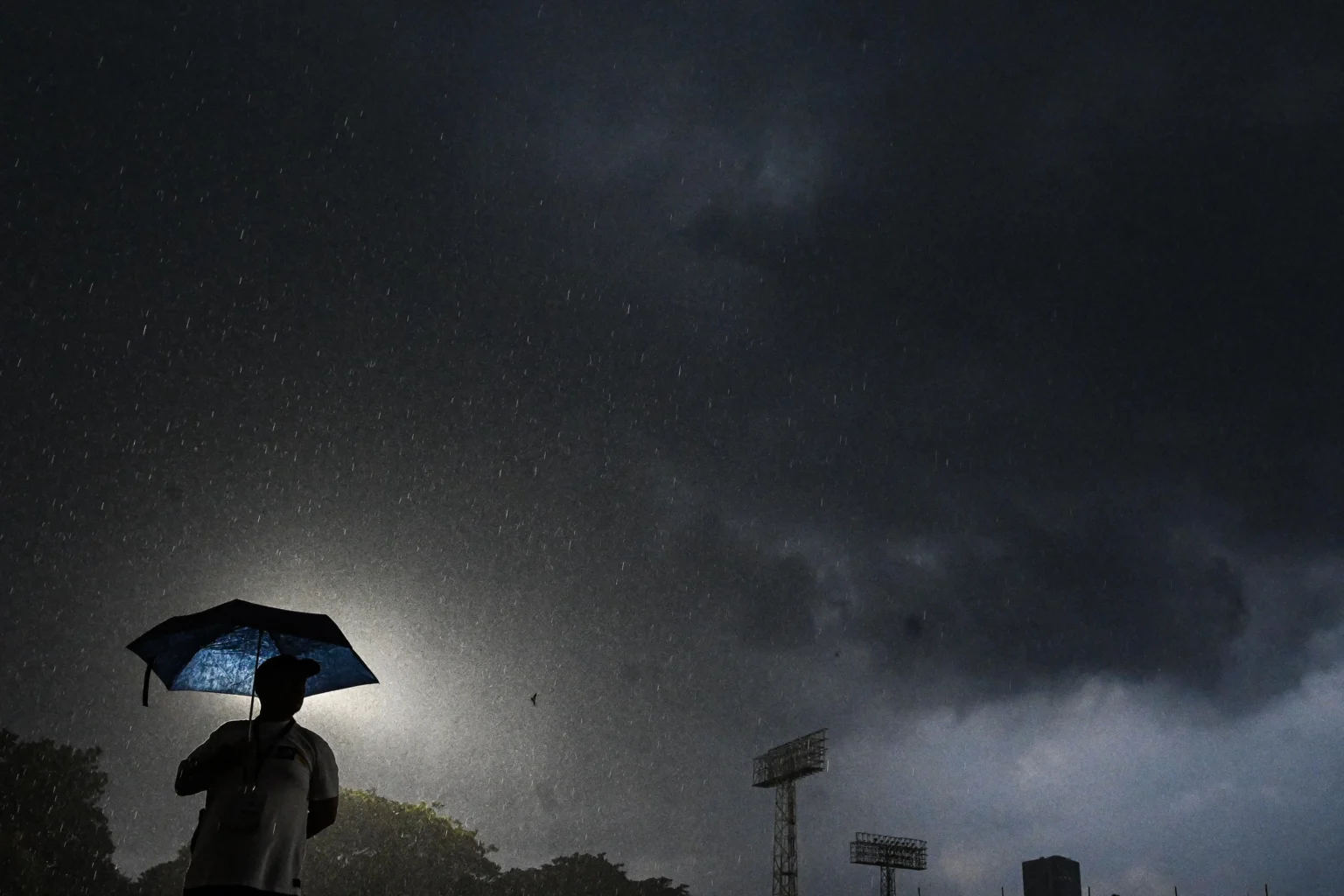 Ilustrasi, seorang warga menggunakan payung saat hujan deras di Jakarta