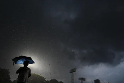 Ilustrasi, seorang warga menggunakan payung saat hujan deras di Jakarta