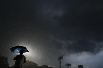 Seorang warga menggunakan payung saat hujan deras di Jakarta