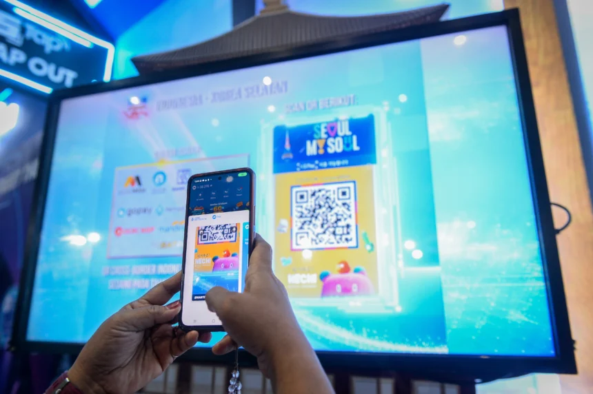 Pengunjung mencoba memindai QRIS Korea Selatan saat Festival Ekonomi dan Keuangan Digital (FEKDI) x Indonesia Fintech Summit & Expo (IFSE) 2025 di Jakarta, Kamis (30/10/2025). Bank Indonesia mulai melakukan uji coba terbatas atau sandbox sistem pembayaran digital QRIS lintas negara antara Indonesia-Korea Selatan dan ditargetkan berjalan penuh mulai tahun 2026 guna memperkuat konektivitas ekonomi digital regional.