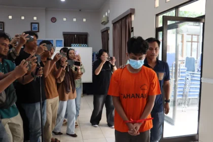 Tampang pelaku Hilmi peneror bom 10 sekolah dengan mengatasnamakan Kamila memakai baju tahanan Polres Depok.