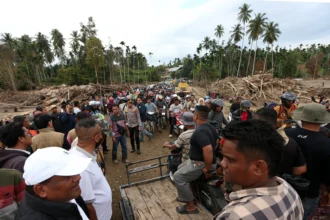 Warga dengan menggunakan kendaraan melewati Jembatan Bailey Awe Geutah yang baru selesai dibangun setelah sebelumnya putus akibat bencana banjir bandang di Bireuen, Aceh
