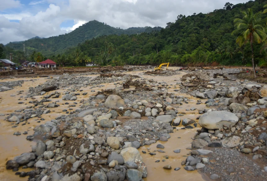 Operator mengoperasikan alat berat untuk membersihkan lokasi dari material banjir bandang di aliran Sungai Batang Kuranji, Batu Busuk, Padang, Sumatera Barat