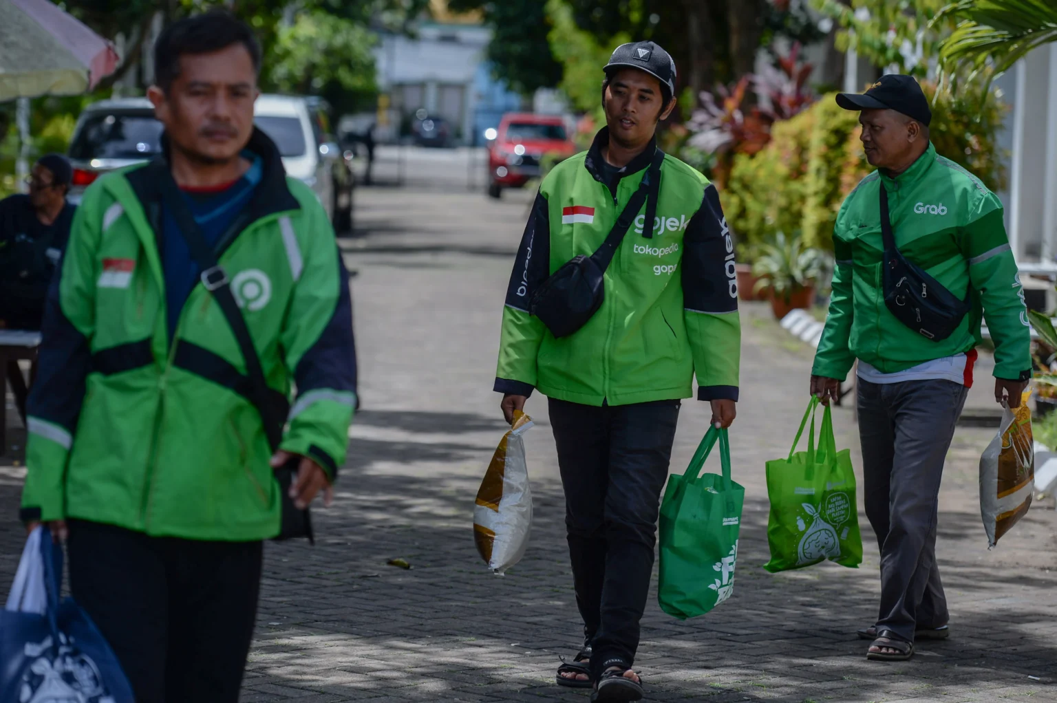 Pengemudi ojek online membawa paket sembako yang mereka terima di Kota Serang, Banten, Jumat (28/11/2025).